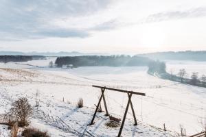 a snow covered field with a fence in the foreground at Individual room surrounded by nature in Sankt Georgen bei Salzburg