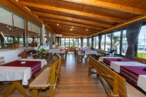a restaurant with tables and chairs and windows at Guesthouse 3 Diamonds in Omarë +43 photos