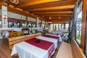 a restaurant with tables and chairs and windows at Guesthouse 3 Diamonds in Omarë