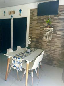 a table and chairs in a room with a wall at Marea Azul Guanacaste in Puerto Soley