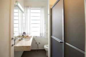 a bathroom with a sink and a toilet and a window at Hotel Normandie - by Easy Hotéis in São Paulo