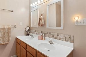 a bathroom with a white sink and a mirror at Gorgeous 3 Bedroom Condo with Ocean Views & Garage Parking in Wildwood