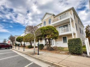 a house on a street with a car parked in front at Gorgeous 3 Bedroom Condo with Ocean Views & Garage Parking in Wildwood