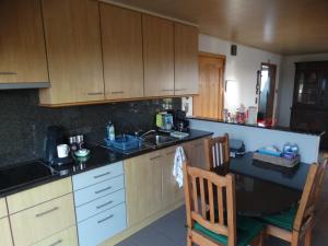 a kitchen with wooden cabinets and a black counter top at 'T Lang Zweerd in Middelkerke