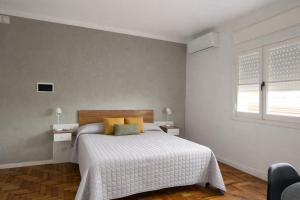 a bedroom with a bed with yellow pillows and a window at Ana Rent II Departamento Moderno ,equipado en San Isidro cerca de Tigre River y Tecnopolis in Boulogne