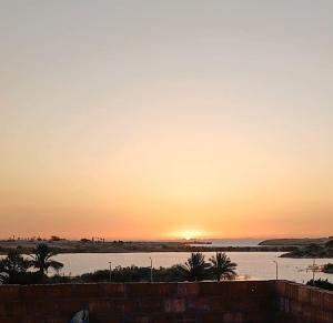 a sunset over a body of water with at Nabo House in Abu Simbel