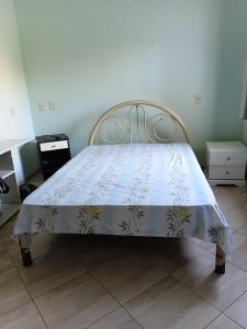 a bed with a blue and white blanket on it at Recanto Seu sossego ! in Maricá
