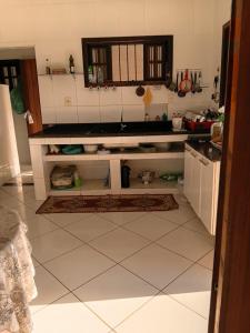 a kitchen with white tile floors and a counter top at Recanto Seu sossego ! in Maricá +6 photos