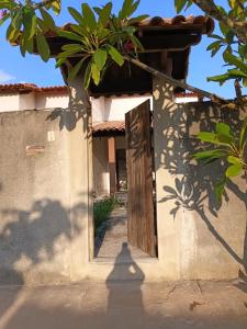 an open door to a house with a tree at Recanto Seu sossego ! in Maricá