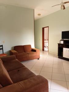 a living room with two brown couches and a tv at Recanto Seu sossego ! in Maricá