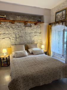 a bedroom with a large bed and a stone wall at Ankora in Omiš