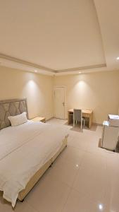 a bedroom with a large bed and a desk at استديو داخل بناية حي النرجس in Riyadh