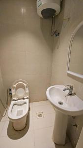 a bathroom with a toilet and a sink at استديو داخل بناية حي النرجس in Riyadh