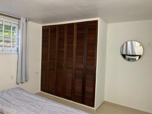 a bedroom with a wooden shutter door and a mirror at Kelly's Vacation Nest to Relax and Reactivate in Willemstad