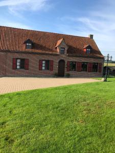a large brick house with a green lawn in front of it at Ons Heerens Boompje in Poperinge