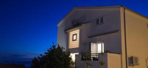 a white building with a window at night at Apartments Buljan in Kožino