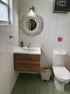 a bathroom with a toilet and a sink and a mirror at Blue Lagoon Apartment in Lagun