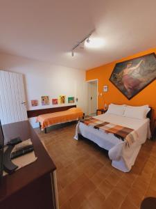 a large room with two beds and a desk at Hotel Pousada Cachalote in Coruripe +55 photos