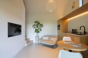 a living room with a table and a chair at Guesthouse 'Elements' with panoramic views in Bergen