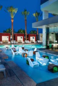 a swimming pool with white chairs and palm trees at Justin's at Palms Place in Las Vegas