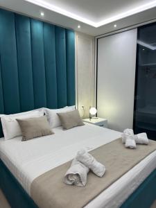 a bedroom with a large bed with towels on it at Glenis Apartment Vollga in Durrës