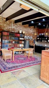 a library with a wooden table and chairs and books at 007 Loft in Mossel Bay