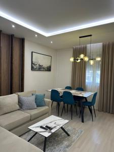 a living room with a couch and a table and chairs at Glenis Apartment Vollga in Durrës