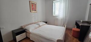 a small bedroom with a bed and a window at Apartments Buljan in Kožino
