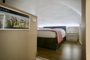 a bedroom with a bed and a flat screen tv at Margaret Home- Casa Vacanze con Self Check In in Gravina in Puglia