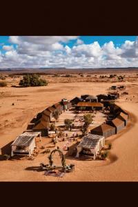 a group of buildings in the middle of a desert at Sahara wellness camp in Merzouga