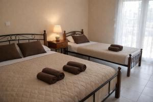 a bedroom with two beds and a lamp on a table at Noufara Apartments in Nea Mesangala