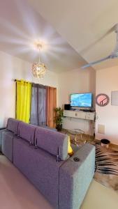 a living room with a purple couch and a tv at Cozy 1 bedroom in Punta Cana