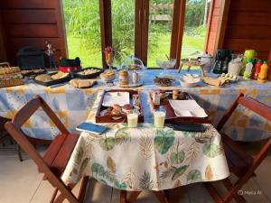 a table with a blue and white table cloth at Chalé Manancial in Socorro +36 photos