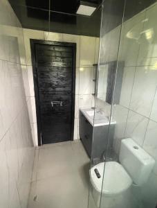 a bathroom with a toilet and a sink and a door at Chalè Aurora do vale in Cobras +32 photos