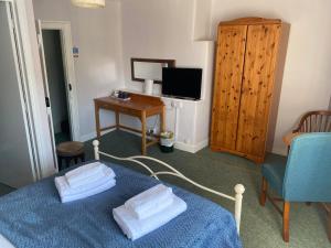 a bedroom with a blue bed with towels on it at The Phelips Arms in Montacute