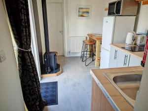 a kitchen with a stove in the middle of a room at Half Pint in Tain