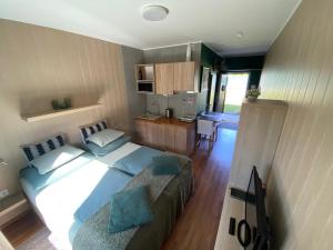 a bedroom with a large bed and a kitchen at Ölyv in Fertőrákos
