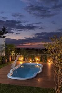 a swimming pool in a backyard at night at Cabanas Farol in Pântano Grande