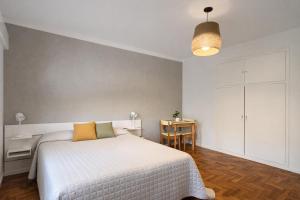 a bedroom with a white bed and a desk and a table at Ana Rent lll Moderno departamento ,San Isidro punto medio Tigre River y Tecnopolis in Boulogne