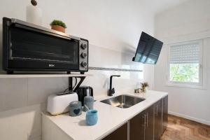 a kitchen with a sink and a microwave at Ana Rent lll Moderno departamento ,San Isidro punto medio Tigre River y Tecnopolis in Boulogne