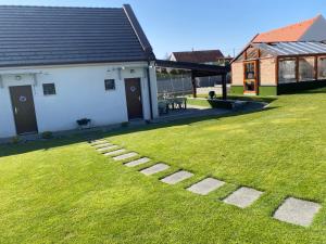 a yard with a building and a grassy field at Ölyv in Fertőrákos