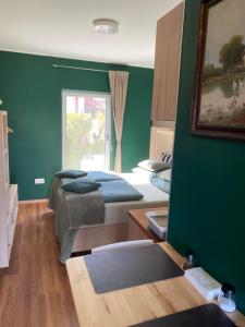 a green room with two beds and a window at Ölyv in Fertőrákos +10 photos