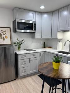 a kitchen with white cabinets and a table and a microwave at Yellow Gate Executive Retreat in San Jose