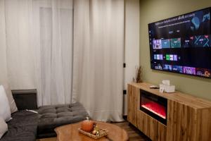 a living room with a large flat screen tv at El Koulador House in Ialysos