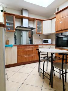 a kitchen with wooden cabinets and a table and chairs at Chambre B1 in Toulouse