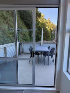 a table and chairs on a balcony with a view at Stylish Private Apartment, Close to Ferry, Stadium, Parking in Wellington