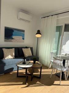 a living room with a blue couch and a table at Green Almond D1 in Orfánion