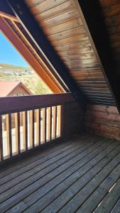 a wooden porch with a wooden railing on a deck at Memórias da Serra - Chalé Serra da Estrela Penhas da Saude in Penhas da Saúde