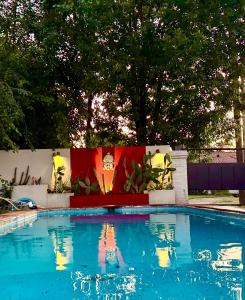 a swimming pool with a painting on a wall at Espacio Nidra - Tu descanso a pasos del Aeropuerto in Ezeiza