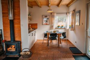 a kitchen with a stove and a table with chairs at tuŻur domki nad potokiem in Osie